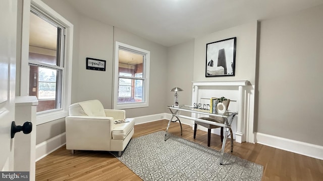 office space featuring a wealth of natural light, baseboards, and wood finished floors