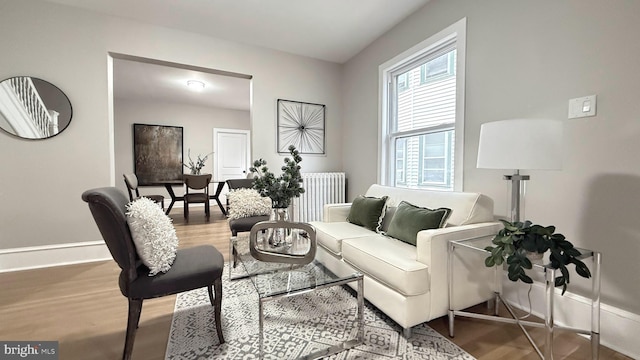 living room with baseboards, radiator heating unit, and wood finished floors