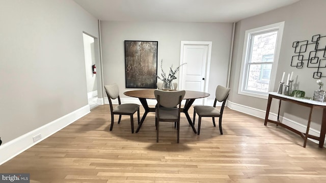 dining space with light wood-style floors and baseboards