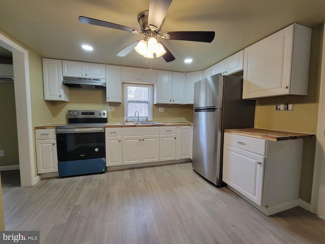 kitchen featuring light wood-style flooring, appliances with stainless steel finishes, white cabinets, a sink, and under cabinet range hood