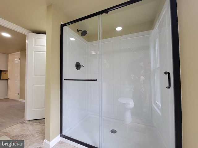 bathroom with a stall shower, toilet, baseboards, and recessed lighting