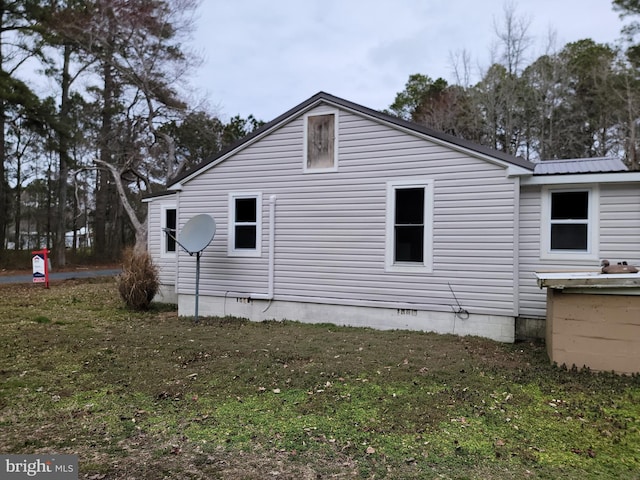 view of side of property with metal roof and crawl space