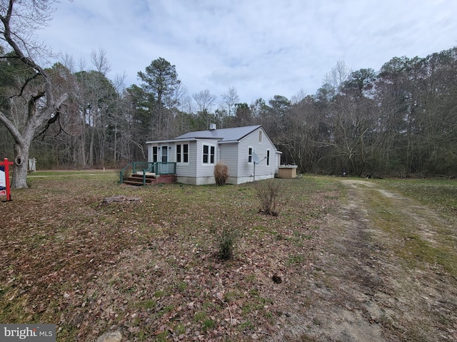 view of front of property with metal roof and a wooded view