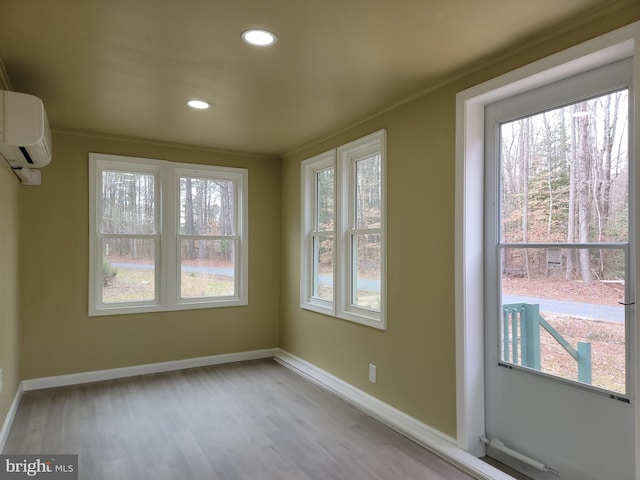 interior space with an AC wall unit and a healthy amount of sunlight