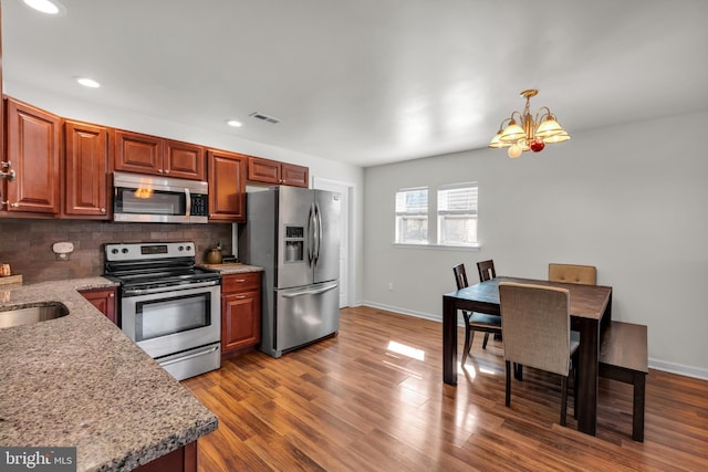 kitchen featuring tasteful backsplash, visible vents, stainless steel appliances, and dark wood-style floors