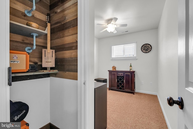 interior space with visible vents, carpet flooring, baseboards, and ceiling fan