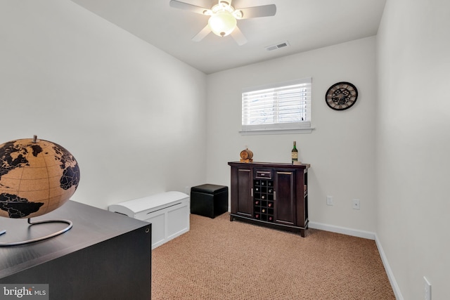 home office with visible vents, light carpet, baseboards, and a ceiling fan