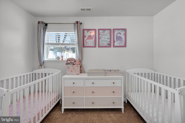 carpeted bedroom featuring a nursery area and visible vents