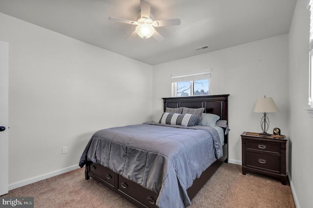 bedroom featuring ceiling fan, light colored carpet, visible vents, and baseboards