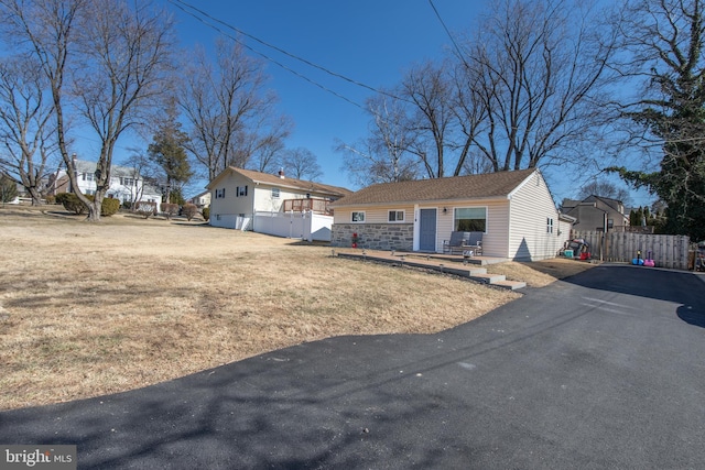 single story home with an outdoor structure, a front yard, and fence