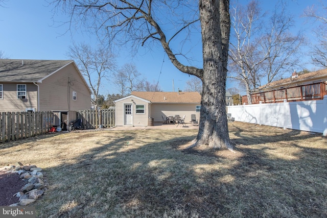 rear view of property featuring a patio, a yard, and a fenced backyard