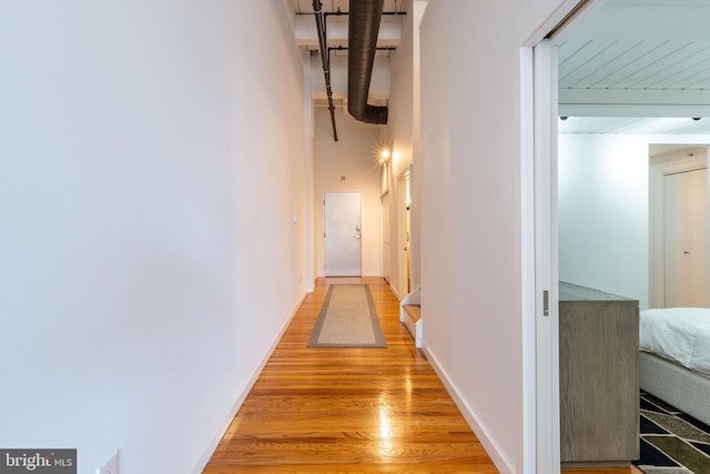 corridor with baseboards and light wood-style floors