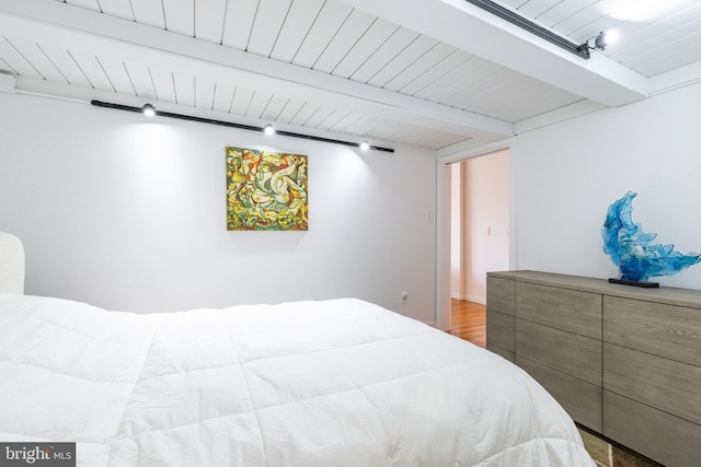 bedroom with beam ceiling, wood ceiling, and wood finished floors