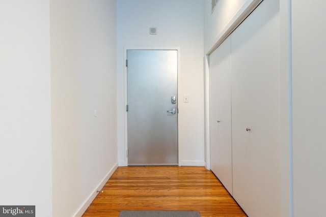 hallway with light wood finished floors and baseboards