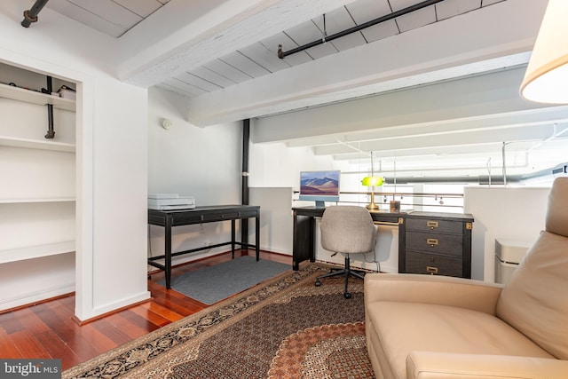 office area with dark wood finished floors, beam ceiling, and baseboards