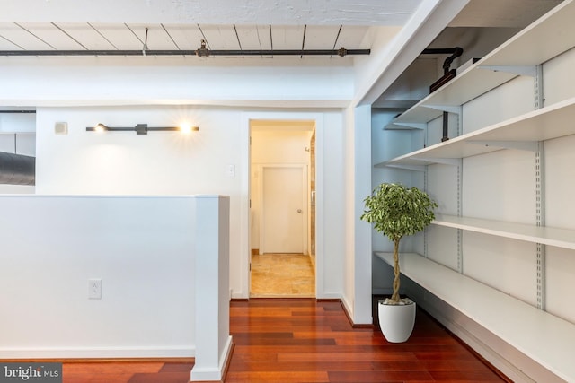 corridor with dark wood-style flooring