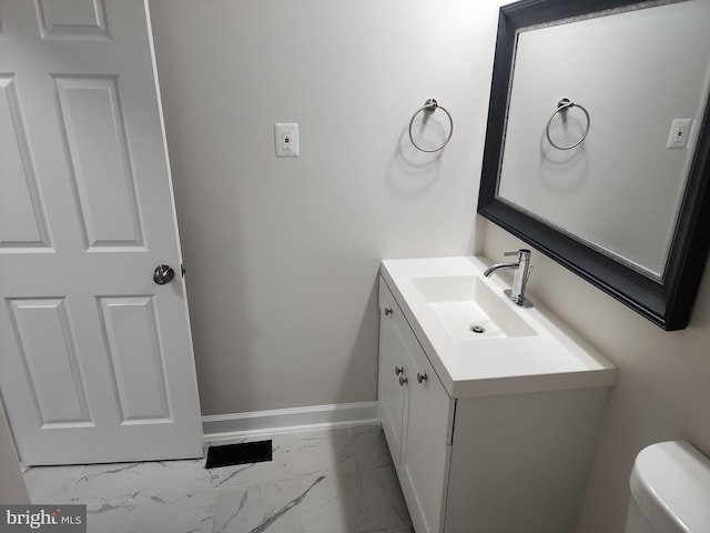 half bath with vanity, marble finish floor, baseboards, and toilet