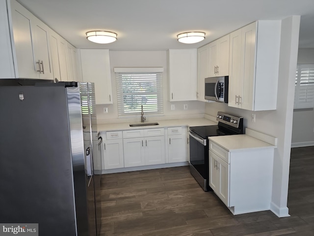 kitchen featuring stainless steel appliances, dark wood-style floors, white cabinets, and a sink