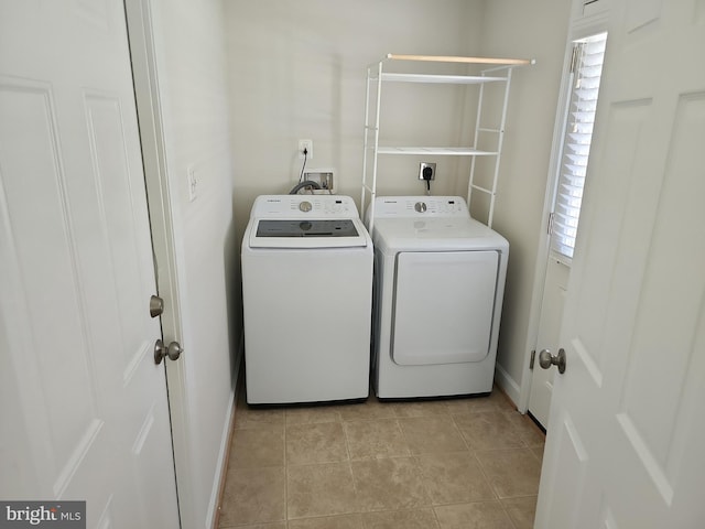 laundry room featuring a healthy amount of sunlight, washer and clothes dryer, baseboards, and laundry area