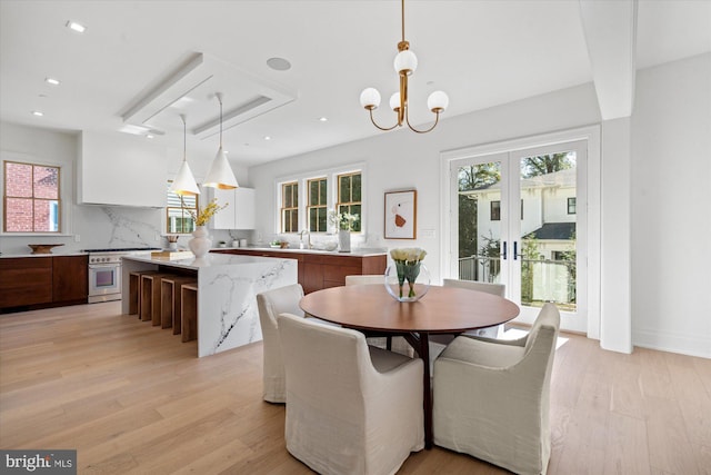 dining space with a healthy amount of sunlight, light wood finished floors, a chandelier, and recessed lighting