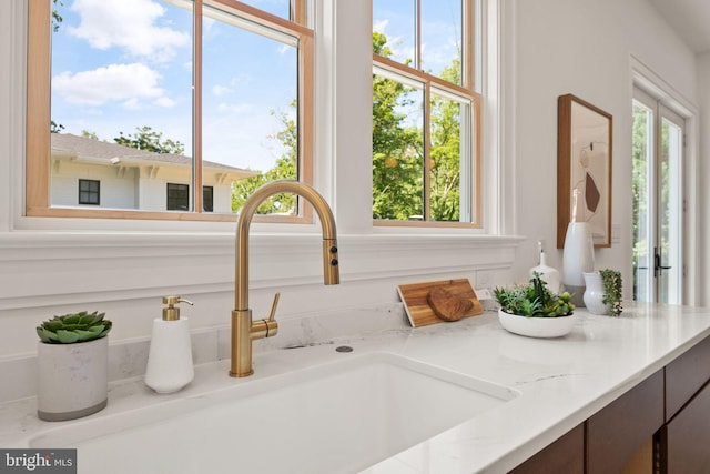 room details featuring a sink and light stone countertops