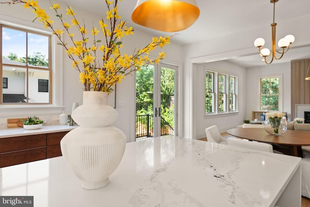 dining room with plenty of natural light, a fireplace, and a notable chandelier