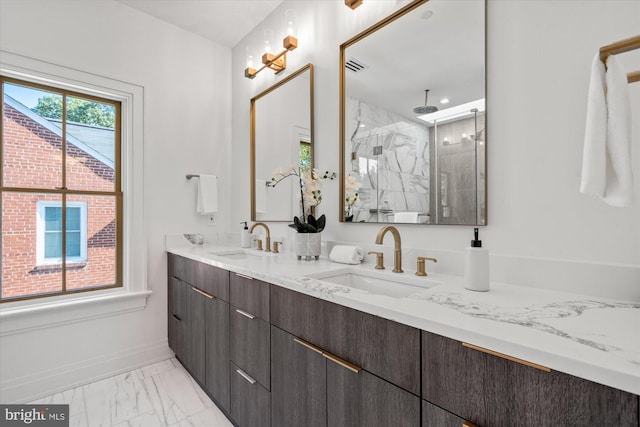 full bath featuring marble finish floor, a sink, a marble finish shower, and baseboards