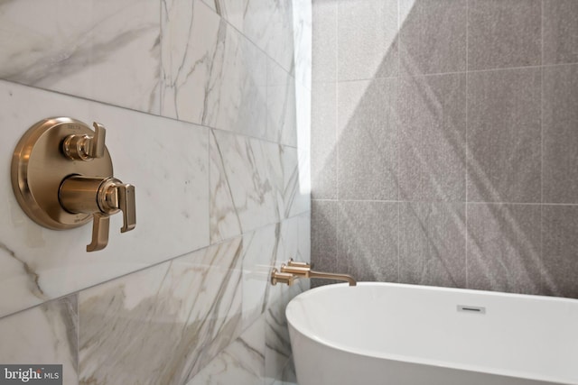 full bathroom featuring a freestanding tub and tile walls