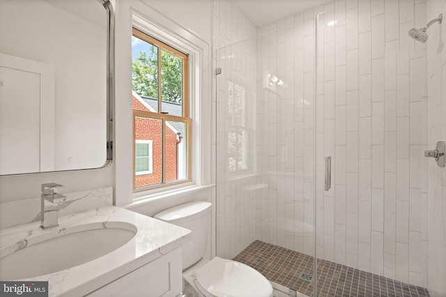 full bath featuring a stall shower, vanity, and toilet