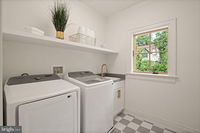 laundry room with cabinet space, baseboards, washer and clothes dryer, light floors, and a sink