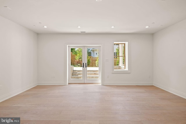 spare room with light wood-style floors, recessed lighting, baseboards, and french doors