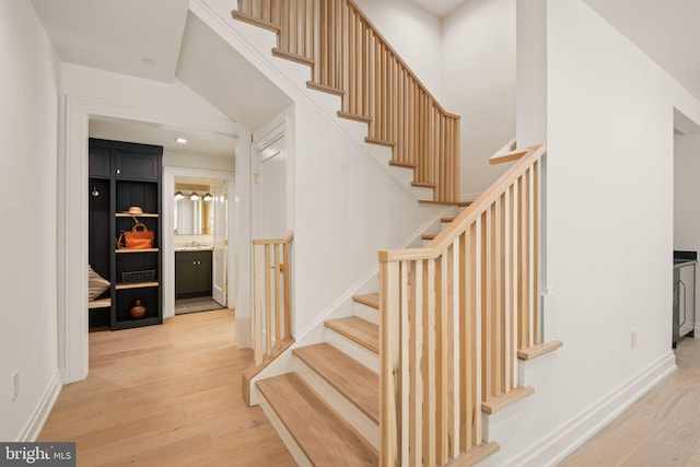 staircase with recessed lighting, wood finished floors, and baseboards