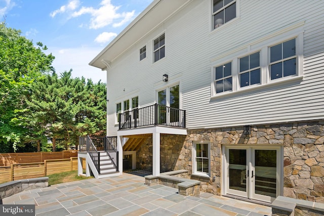 back of property featuring a deck, fence, french doors, stairway, and a patio area