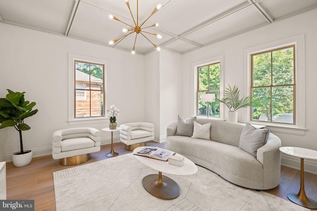 living room featuring plenty of natural light, baseboards, a chandelier, and wood finished floors