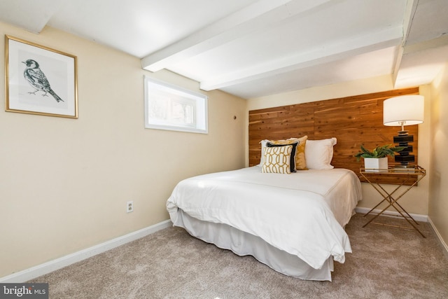 carpeted bedroom with baseboards and beam ceiling