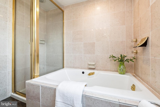 full bathroom featuring a shower stall, tile walls, and a garden tub