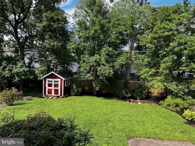 view of yard featuring a fenced backyard, a storage shed, and an outdoor structure