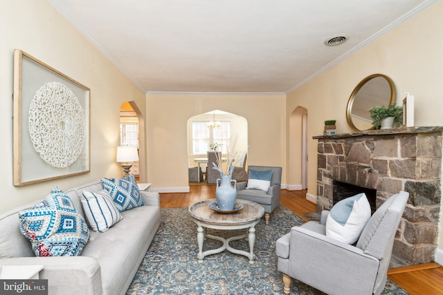 living area with visible vents, wood finished floors, and arched walkways