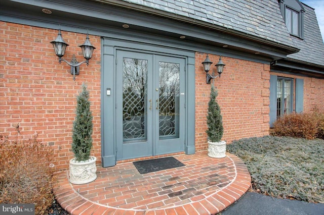 doorway to property featuring french doors and brick siding