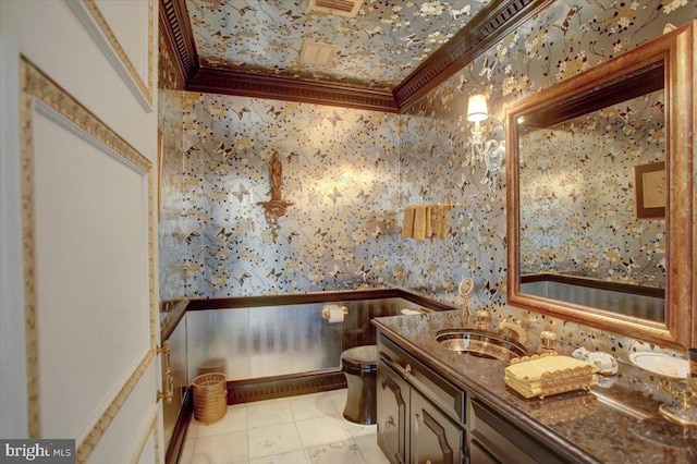 bathroom with ornamental molding, a sink, and wallpapered walls