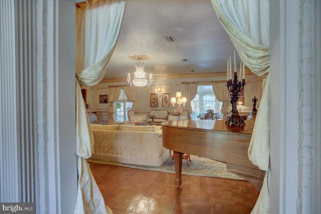 tiled living area with crown molding, visible vents, and a notable chandelier