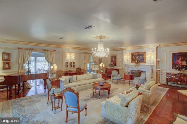 living area with a fireplace, visible vents, a decorative wall, ornamental molding, and a chandelier