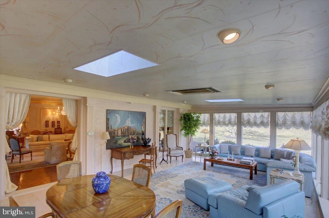 living area featuring a skylight, a notable chandelier, crown molding, visible vents, and wood finished floors