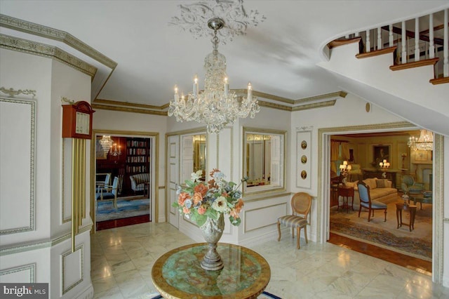 interior space featuring an inviting chandelier, stairway, marble finish floor, and crown molding