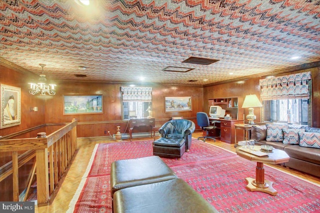 living area with wooden walls, a chandelier, and crown molding