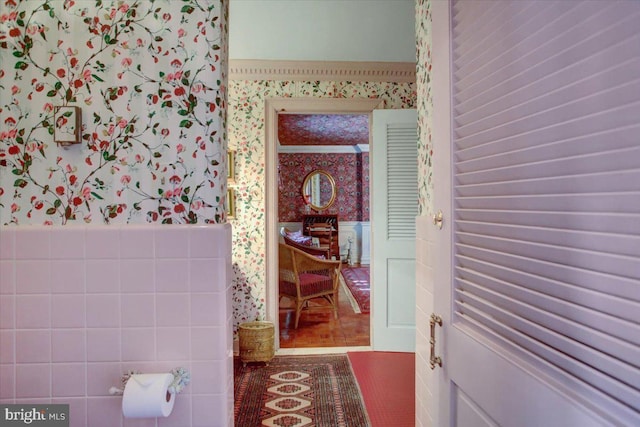 bathroom featuring a wainscoted wall, tile patterned floors, and wallpapered walls