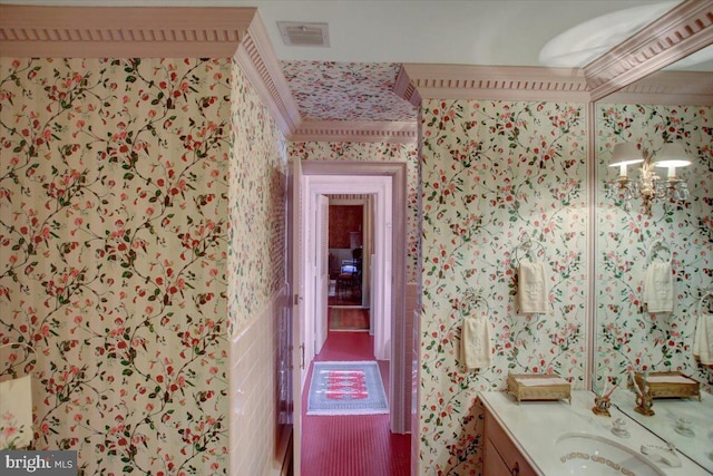 bathroom with wallpapered walls, visible vents, and vanity