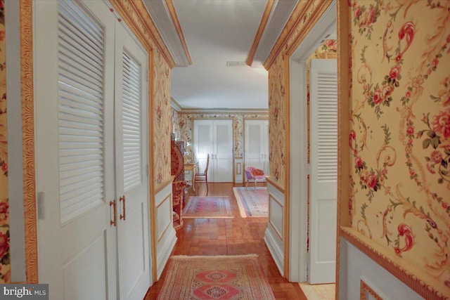 hallway featuring light wood-type flooring, wallpapered walls, and crown molding