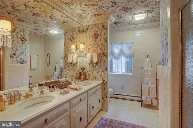 bathroom with a baseboard radiator, a sink, toilet, and wallpapered walls