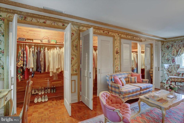 interior space featuring crown molding, visible vents, and wallpapered walls